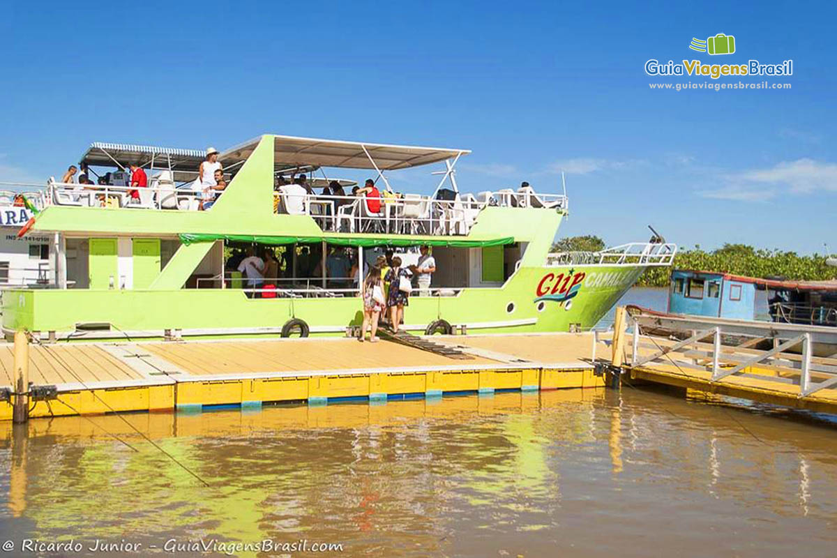 Imagem de turistas entrando no barco camaleão.